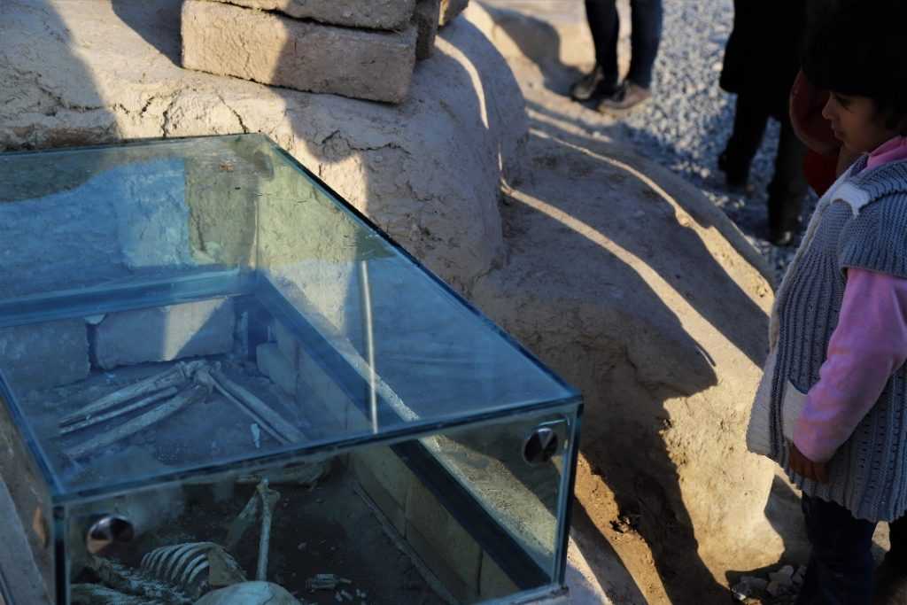 Der Konflikt zwischen der Kindheit und mehreren tausend Jahre alten Knochen in Kashans Sialk Hill in einem Rahmen.